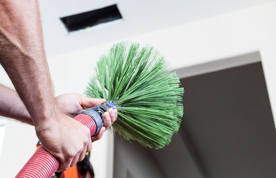 HVAC technician performing professional duct cleaning service in San Antonio home