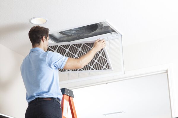 HVAC technician performing professional duct cleaning service in San Antonio home